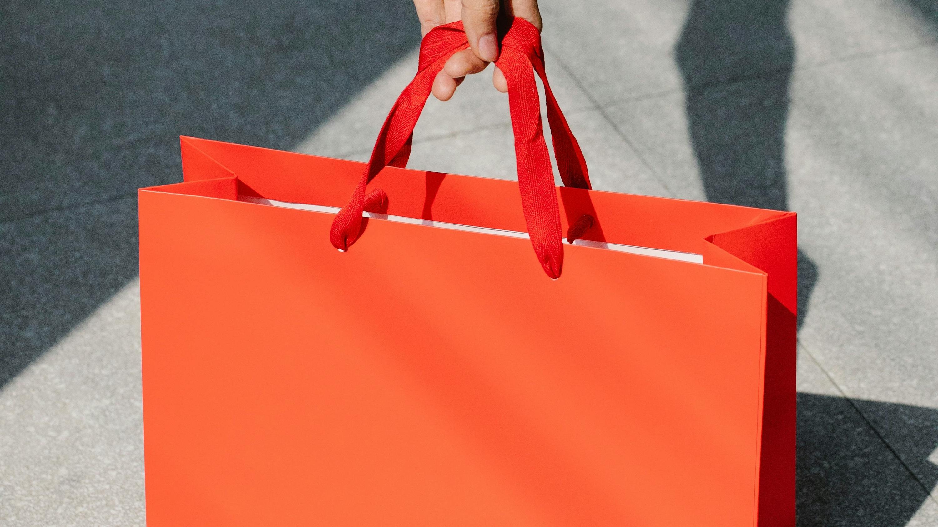 Hand holding a shopping bag handle